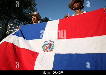 Karneval-Teilnehmer mit Dominikanische Nationalflagge führen während der Dominikanischen Karneval in Santo Domingo, Dominikanische Republik. Stockfoto