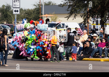 Junge Verkauf von Ballons und Blow-up Spielzeug von einer Karre am Citrus Parade in der Mission, Texas, USA Stockfoto