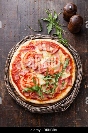 Italienische Pizza mit Schinken und Rucola Blätter auf Holztisch Stockfoto