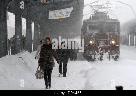 Bukarest, Rumänien. 29. Januar 2014. Passagiere Fuß im Schnee am Hauptbahnhof in Bukarest, Hauptstadt Rumäniens, 29. Januar 2014. Ein neuen schweren Schneesturm begann Mittwoch, Rumäniens Hauptstadt sowie im Süden und Südosten zu schlagen. die rumänischen Behörden erklärt den Ausnahmezustand in vier weitere Grafschaften Ialomita, Calarasi, Constanta und Tulcea, besser als Reaktion auf die aktuellen Schneesturm ermöglichen. Bildnachweis: Gabriel Petrescu/Xinhua/Alamy Live-Nachrichten Stockfoto