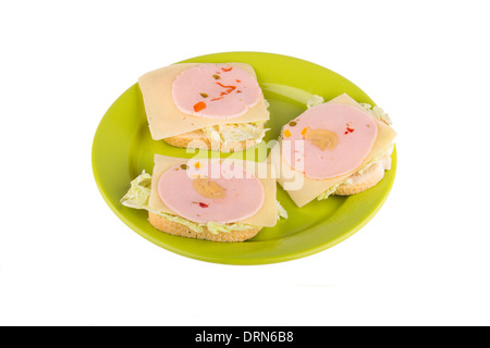 Brötchen mit Wurst auf eine grüne Platte isoliert auf weißem Hintergrund. Stockfoto