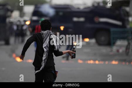 Manama, Bahrain. 29. Januar 2014. Bahrainische Anti-Regierungs-Demonstranten werfen Molotowcocktails als Polizei feuert Tränengas bei einem Zusammenstoß im westlichen Vorort von Manama, Hauptstadt von Bahrain, am 29. Januar 2014. Seit Februar 2011 haben Bahrains schiitischen Muslime Anti-Regierungs-Proteste anspruchsvolle Reformen und einen größeren Anteil an der macht begonnen, aus sunnitischen königlichen Familie regiert. Credit: Foto/Hasan Jamali/Xinhua/Alamy Live-Nachrichten Stockfoto