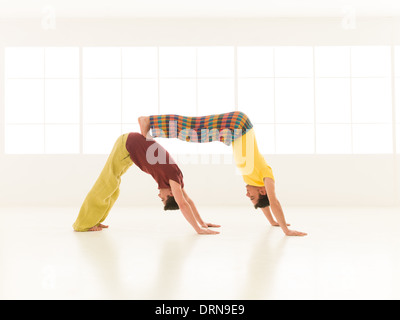 Menschen in lebendigen Farben gekleidet führen Yoga bewegt Stockfoto