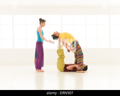 Menschen in lebendigen Farben gekleidet führen Yoga bewegt innen Stockfoto