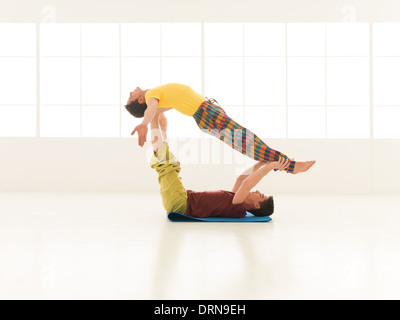 Menschen in lebendigen Farben gekleidet ausführen Yoga bewegt Nachauftragnehmer Stockfoto