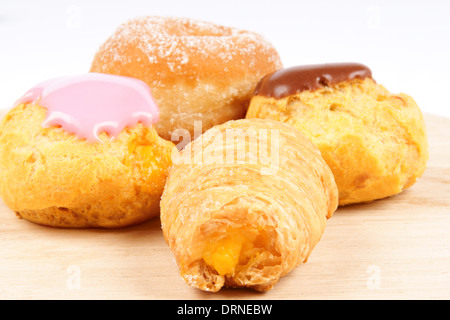 Verschiedene Tee-Kuchen auf einer Holzplatte auf einem weißen Stoff-Hintergrund. Stockfoto