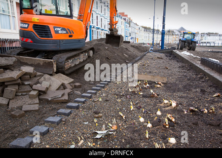 Nach einer Woche der Springfluten, Sturmfluten und Sturmwinde Kraft hat die Strandpromenade von Aberystwyth in Wales, mit Millionen von Pfund Schaden verwüstet. Die brechenden Wellen schlug ein großes Loch in den Deich und ist zusammengebrochen Aberystwyths kultigen, viktorianischen Promenade Unterschlupf, die seit über 100 Jahren stehen geblieben. Dieses Bild entstand auf Mittwoch, 8. Januar 2014, der Tag begann der Rat, zu versuchen, und deaktivieren Sie die Tausende von Tonnen Schutt Strand Meer Offroad. Stockfoto