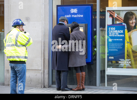 Paar bei Cashpoint der Halifax Bank kuscheln Stockfoto