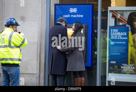 Paar bei Cashpoint der Halifax Bank kuscheln Stockfoto