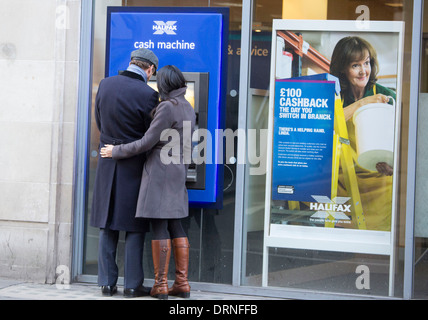 Paar bei Cashpoint der Halifax Bank kuscheln Stockfoto