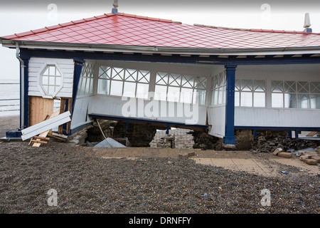 Nach einer Woche der Springfluten, Sturmfluten und Sturmwinde Kraft hat die Strandpromenade von Aberystwyth in Wales, mit Millionen von Pfund Schaden verwüstet. Die Crsahing Wellen schlug ein großes Loch in den Deich und zusammengebrochen Aberystwyths kultigen, viktorianischen Promenade Unterschlupf, die seit über 100 Jahren stehen geblieben. Dieses Bild entstand auf Mittwoch, 8. Januar 2014, der Tag begann der Rat, zu versuchen, und deaktivieren Sie die Tausende von Tonnen Schutt Strand Meer Offroad. Stockfoto