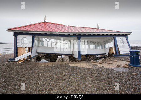 Nach einer Woche der Springfluten, Sturmfluten und Sturmwinde Kraft hat die Strandpromenade von Aberystwyth in Wales, mit Millionen von Pfund Schaden verwüstet. Die Crsahing Wellen schlug ein großes Loch in den Deich und zusammengebrochen Aberystwyths kultigen, viktorianischen Promenade Unterschlupf, die seit über 100 Jahren stehen geblieben. Dieses Bild entstand auf Mittwoch, 8. Januar 2014, der Tag begann der Rat, zu versuchen, und deaktivieren Sie die Tausende von Tonnen Schutt Strand Meer Offroad. Stockfoto