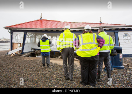 Nach einer Woche der Springfluten, Sturmfluten und Sturmwinde Kraft hat die Strandpromenade von Aberystwyth in Wales, mit Millionen von Pfund Schaden verwüstet. Die brechenden Wellen schlug ein großes Loch in den Deich und ist zusammengebrochen Aberystwyths kultigen, viktorianischen Promenade Unterschlupf, die seit über 100 Jahren stehen geblieben. Dieses Bild entstand auf Mittwoch, 8. Januar 2014, der Tag begann der Rat, zu versuchen, und deaktivieren Sie die Tausende von Tonnen Schutt Strand Meer Offroad. Stockfoto