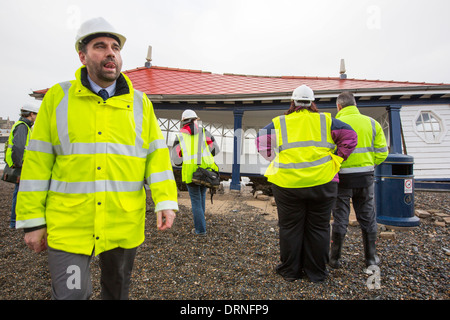 Nach einer Woche der Springfluten, Sturmfluten und Sturmwinde Kraft hat die Strandpromenade von Aberystwyth in Wales, mit Millionen von Pfund Schaden verwüstet. Die brechenden Wellen schlug ein großes Loch in den Deich und ist zusammengebrochen Aberystwyths kultigen, viktorianischen Promenade Unterschlupf, die seit über 100 Jahren stehen geblieben. Dieses Bild entstand auf Mittwoch, 8. Januar 2014, der Tag begann der Rat, zu versuchen, und deaktivieren Sie die Tausende von Tonnen Schutt Strand Meer Offroad. Stockfoto