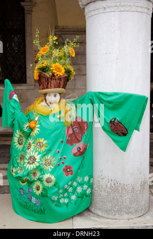 Komisch gekleideten Teilnehmer von der Karneval von Venedig, Italien, lehnte sich gegen einen Pfeiler im St. Marks Square. Stockfoto