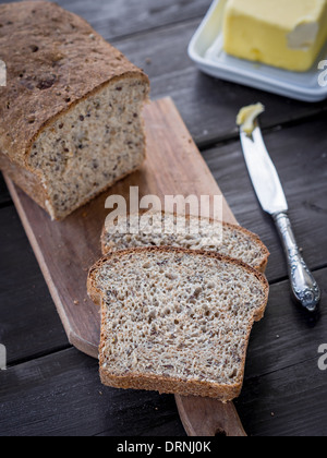 Frische hausgemachte Vollkorn Weizenbrot mit "Linum" und Cannabis, serviert mit Butter. Stockfoto