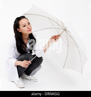 Ärztin nimmt weißen Regenschirm für Portrait. Stockfoto