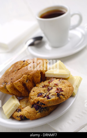 Kekse, Kuchen, weiße Schokolade und Kaffee am Tisch Stockfoto