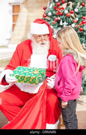 Santa Claus Mädchen Geschenk geben Stockfoto