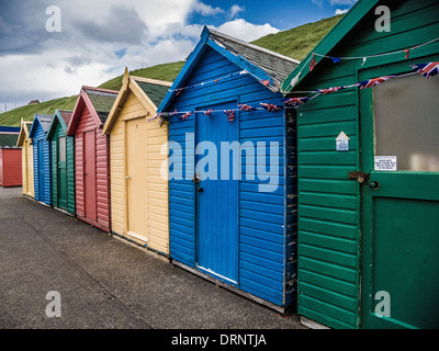 Farbenfrohe Strandhütten am Fuße des West Cliff, Whitby, North Yorkshire. Stockfoto