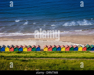 Bunte Strandhütten am Fuße des West Cliff, Whitby, North Yorkshire. Stockfoto