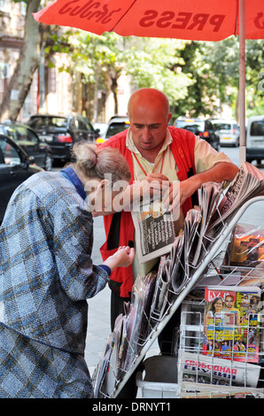 Georgische Seniorin kauft ein Magazin auf der Straße im alten Tbilisi, Georgia - Aug 2013 Stockfoto
