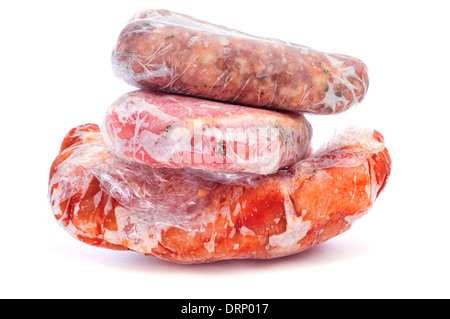 gefrorene Würstchen und anderes Fleisch, eingewickelt in Plastikfolie auf weißem Hintergrund Stockfoto