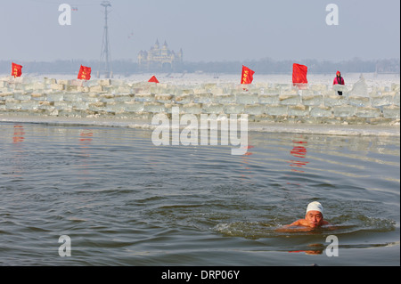 Eis-Schwimmer schwimmt im kalten Wasser des Flusses Songhua, Harbin, China. Ein Loch in das Eis ist offen für die Schwimmer gehalten. Stockfoto