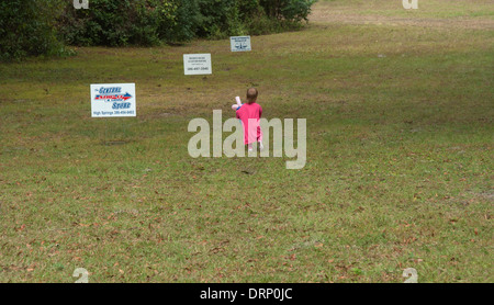 Kleines Kind durchläuft eine Wiese während eines 5K-Renn-Event. Stockfoto