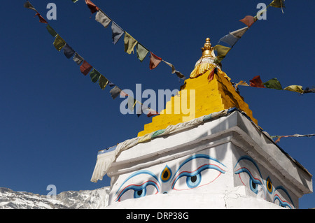 Gebetsfahnen und ein gelber Stupa in Nepal gegen einen klaren blauen Himmel Stockfoto