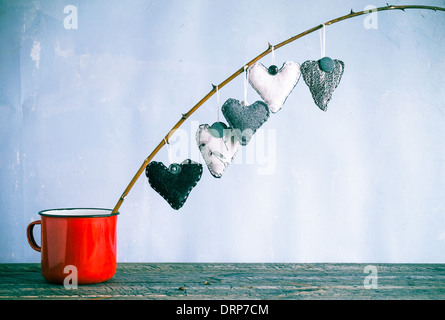 Herz hängt an einem Zweig in eine rote Tasse Stockfoto