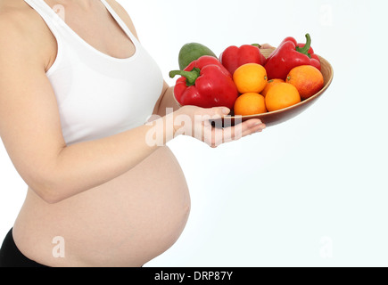 Schwangere Frau mit Obst und Gemüse Schüssel Stockfoto