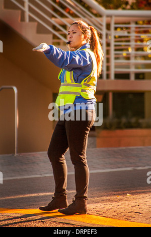 Ein asiatisch-amerikanische Polizeibeamter regelt den Verkehr auf dem Campus der University of California in Irvine. Beachten Sie Sicherheitskleidung. Stockfoto