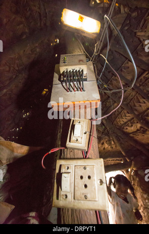 Ein unantastbar Familien Hütte, beleuchtet durch elektrisches Licht, angetrieben durch ein A4 Größe Solarpanel lädt, die eine Batterie Stockfoto