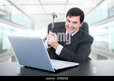 glücklich Kaufmann mit einem Hammer zertrümmern einen Laptop im Büro Stockfoto