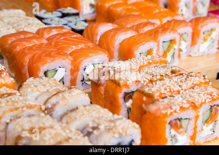 Sortiment-Sushi und Rollen auf Holzplatte in dunkles Licht Stockfoto