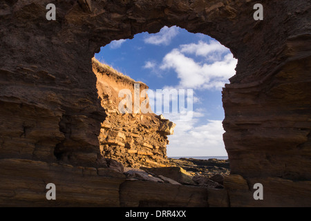 Ein Loch gestanzt in den Klippen in der Nähe von Craster während der schweren Sturmflut vom Dezember 2013, Northumberland, UK. Stockfoto