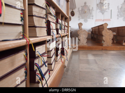 Bücherregal mit Gesangbüchern in einer leeren Kirche in Bayern (Deutschland). Stockfoto