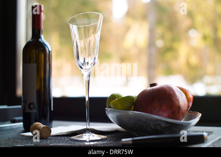 Obst und eine Flasche Rotwein Stockfoto