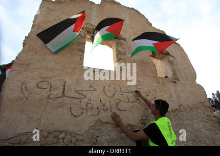 Jordan Vally, Westjordanland, Palästinensische Gebiete. 31. Januar 2014. Eine palästinensische Aktivist schreibt an einer Wand an der Stelle des alten Dorfes bekannt als Ein Hijleh im Jordan-Tal in der Nähe der West Bank Stadt Jericho, 31. Januar 2014. Hunderte von Palästinensern kündigte heute den Start der "Melh Al-ArdÃ ¢? Â (Salz der Erde) Kampagne durch die Wiederbelebung des Dorfes Ein Hijleh im Jordan-Tal auf dem Gelände der orthodoxen Kirche und St. Gerassimos Kloster. Die Kampagne wird gestartet, in der Weigerung der israelischen Politik, die darauf abzielen, Judaizing und das Jordantal zu annektieren (Credit-Bild: © Issam Stockfoto