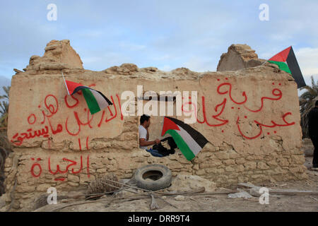 Jordan Vally, Westjordanland, Palästinensische Gebiete. 31. Januar 2014. Eine palästinensische Aktivist hält seine Nationalflagge auf dem Gelände des alten Dorfes bekannt als Ein Hijleh im Jordan-Tal in der Nähe der West Bank Stadt Jericho, 31. Januar 2014. Hunderte von Palästinensern kündigte heute den Start der "Melh Al-ArdÃ ¢? Â (Salz der Erde) Kampagne durch die Wiederbelebung des Dorfes Ein Hijleh im Jordan-Tal auf dem Gelände der orthodoxen Kirche und St. Gerassimos Kloster. Die Kampagne wird gestartet, in der Weigerung der israelischen Politik, die darauf abzielen, Judaizing und das Jordantal zu annektieren (Credit-Bild: © Stockfoto