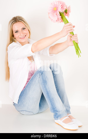 Junge Frau halten rosa Gerbera Daisy Blume Stockfoto