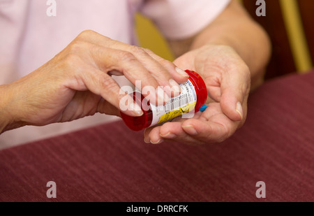 Weibliche 74 Jahre alte Senioren organisiert ihre verschreibungspflichtige Medikament Medikamente während zu Hause Stockfoto