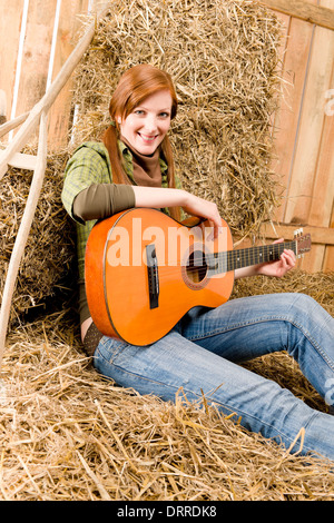 Junges Land Frau mit Gitarre in der Scheune Stockfoto