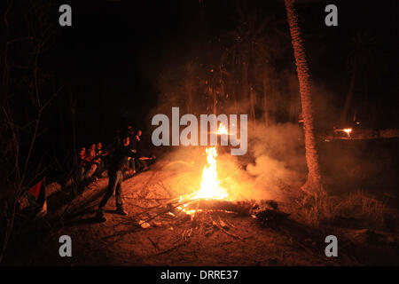 Jordan Vally, Westjordanland, Palästinensische Gebiete. 31. Januar 2014. Palästinensische und ausländische Aktivisten wärmen sich am Feuer auf dem Gelände des alten Dorfes bekannt als Ein Hijleh im Jordan-Tal in der Nähe der West Bank Stadt Jericho, 31. Januar 2014. Hunderte von Palästinensern kündigte heute den Start der Kampagne "Melh Al-Ard" (Salz der Erde) durch die Wiederbelebung des Dorfes Ein Hijleh im Jordan-Tal auf dem Gelände der orthodoxen Kirche und St. Gerassimos Kloster. Die Kampagne wird in der Weigerung der israelischen Politik, die darauf abzielen, Judaizing und annektiert das Jordantal (Credi gestartet. Stockfoto