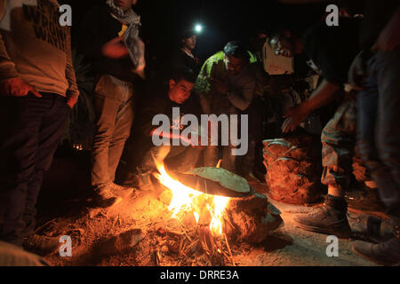 Jordan Vally, Westjordanland, Palästinensische Gebiete. 31. Januar 2014. Palästinensische und ausländische Aktivisten backen Brot am Feuer auf dem Gelände des alten Dorfes bekannt als Ein Hijleh im Jordan-Tal in der Nähe der West Bank Stadt Jericho, 31. Januar 2014. Hunderte von Palästinensern kündigte heute den Start der Kampagne "Melh Al-Ard" (Salz der Erde) durch die Wiederbelebung des Dorfes Ein Hijleh im Jordan-Tal auf dem Gelände der orthodoxen Kirche und St. Gerassimos Kloster. Die Kampagne wird gestartet, in der Weigerung der israelischen Politik, die darauf abzielen, Judaizing und das Jordantal zu annektieren (Credit-Bild: © Stockfoto