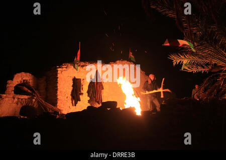 Jordan Vally, Westjordanland, Palästinensische Gebiete. 31. Januar 2014. Palästinensische und ausländische Aktivisten wärmen sich am Feuer auf dem Gelände des alten Dorfes bekannt als Ein Hijleh im Jordan-Tal in der Nähe der West Bank Stadt Jericho, 31. Januar 2014. Hunderte von Palästinensern kündigte heute den Start der Kampagne "Melh Al-Ard" (Salz der Erde) durch die Wiederbelebung des Dorfes Ein Hijleh im Jordan-Tal auf dem Gelände der orthodoxen Kirche und St. Gerassimos Kloster. Die Kampagne wird in der Weigerung der israelischen Politik, die darauf abzielen, Judaizing und annektiert das Jordantal (Credi gestartet. Stockfoto