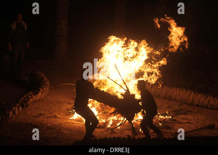 Jordan Vally, Westjordanland, Palästinensische Gebiete. 31. Januar 2014. Palästinensische und ausländische Aktivisten wärmen sich am Feuer auf dem Gelände des alten Dorfes bekannt als Ein Hijleh im Jordan-Tal in der Nähe der West Bank Stadt Jericho, 31. Januar 2014. Hunderte von Palästinensern kündigte heute den Start der Kampagne "Melh Al-Ard" (Salz der Erde) durch die Wiederbelebung des Dorfes Ein Hijleh im Jordan-Tal auf dem Gelände der orthodoxen Kirche und St. Gerassimos Kloster. Die Kampagne wird in der Weigerung der israelischen Politik, die darauf abzielen, Judaizing und annektiert das Jordantal (Credi gestartet. Stockfoto