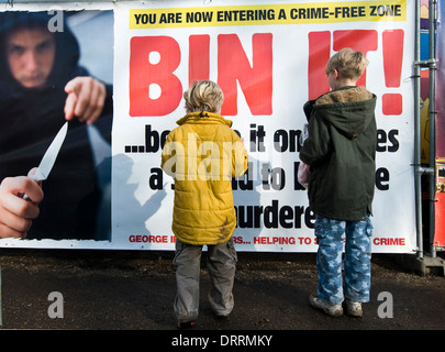 Zwei jungen Blick auf ein Messer Kriminalität Plakat Warnung über die Gefahren von Messern und Bande Kultur von der Polizei ausgestellt Stockfoto