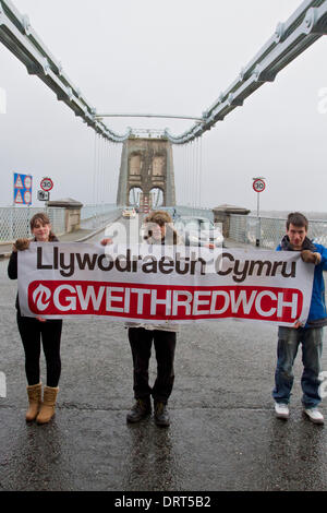 Menai Bridge, North Wales, UK. 1. Februar 2014. Mitglieder von Cymdeithas Jahr Iaith Gymraeg (Welsh Language Society) protestieren bei Brücken in ganz Wales Waliser Regierung, mehr zu tun für den Schutz der walisischen Sprache. Dieses Bild, aufgenommen am 1. Februar 2014 an der Menai Bridge, North Wales, während andere Proteste auf Brücken in ganz Wales abgehalten wurden. Weitere Presseinformationen aus der walisischen Sprache Gesellschaft Offizier Colin Nosworthy: 07971 339542 Credit: Rhys Llwyd/Alamy Live News Stockfoto